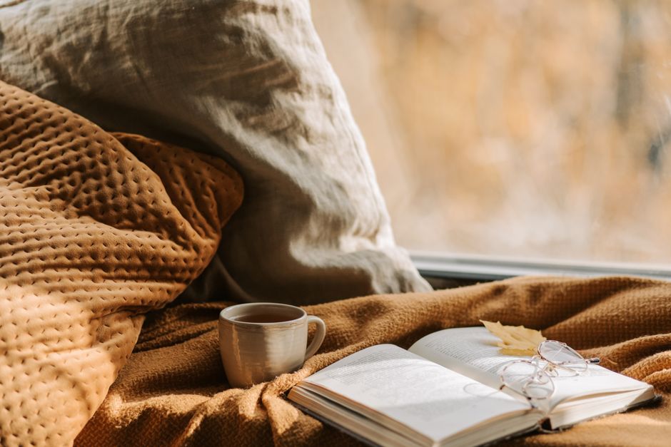 Gezellige stoel bij openhaard vol boeken.